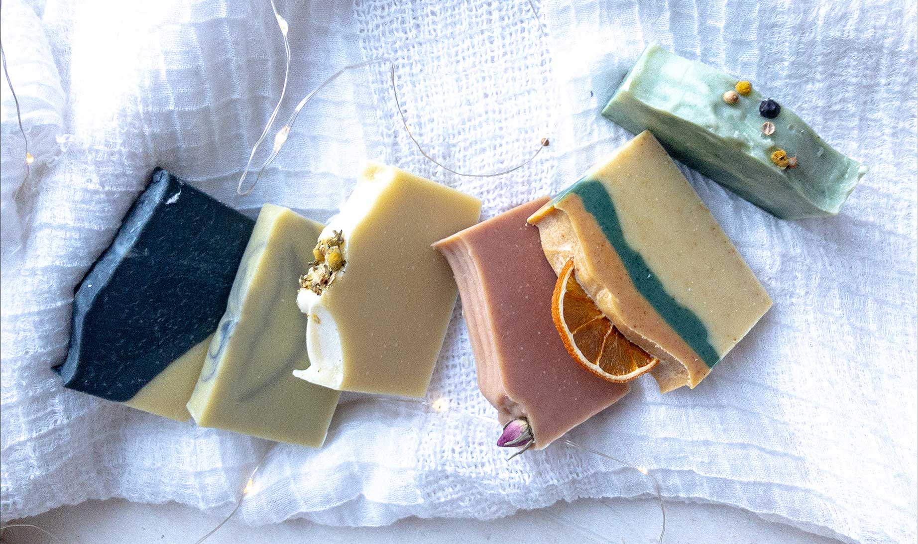 Celtic Flame Savonnerie's soap range spread out on a clean natural cloth